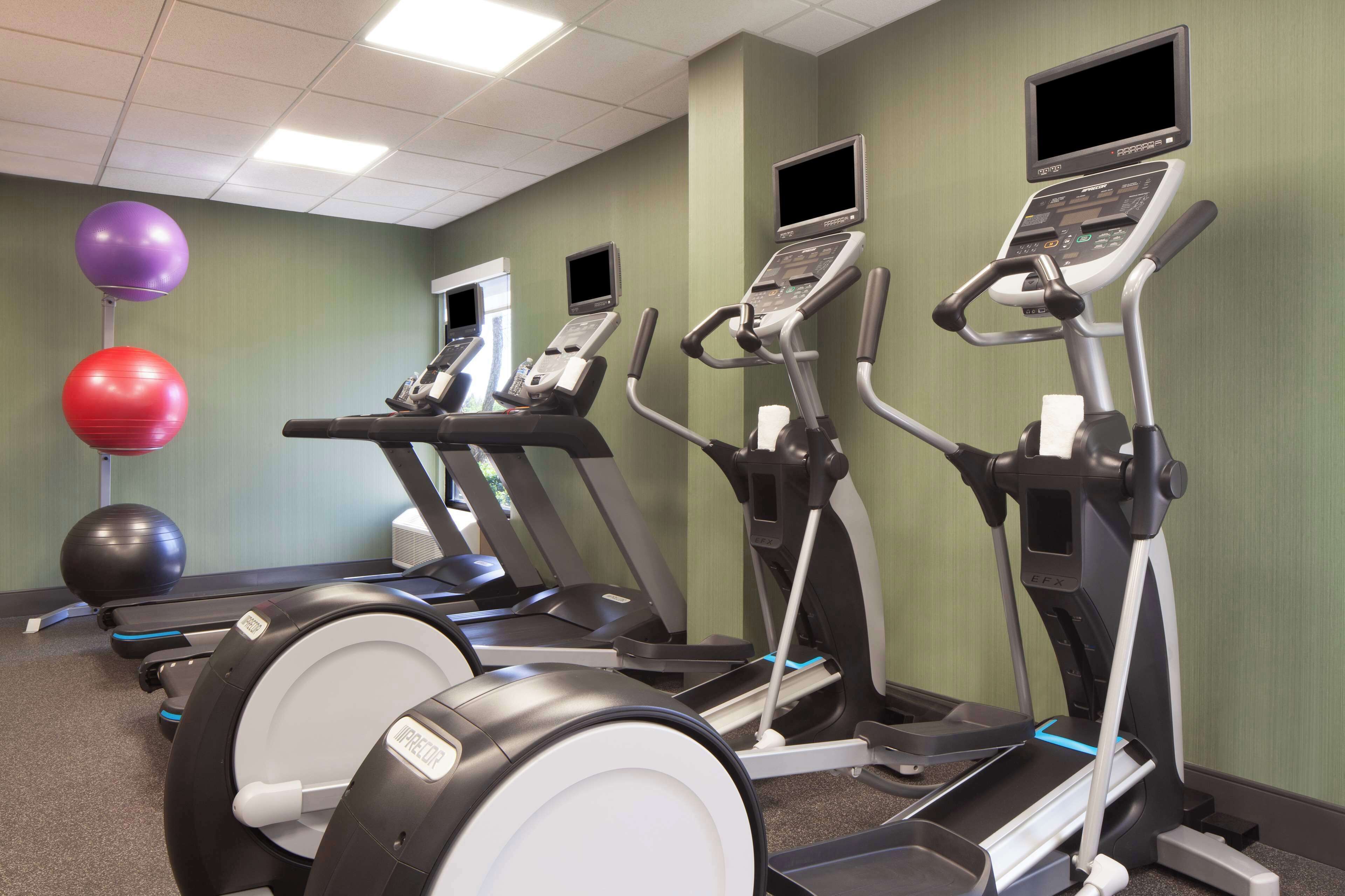 A fitness center with treadmills, exercise balls, and a stationary bike.