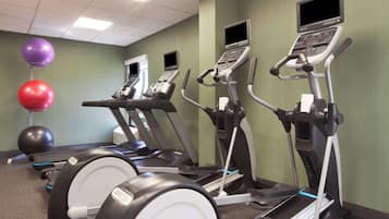 A fitness center with treadmills, exercise balls, and a stationary bike.