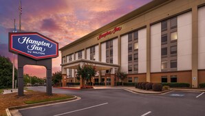Un Hampton Inn de Hilton con un letrero grande, una entrada cubierta y un estacionamiento.
