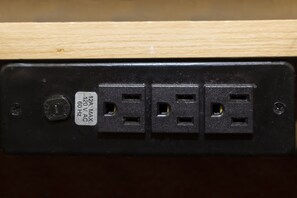 Une prise électrique noire avec une étiquette indiquant 120 V en courant alternatif, 60 Hz, et un courant maximal de 2 A.