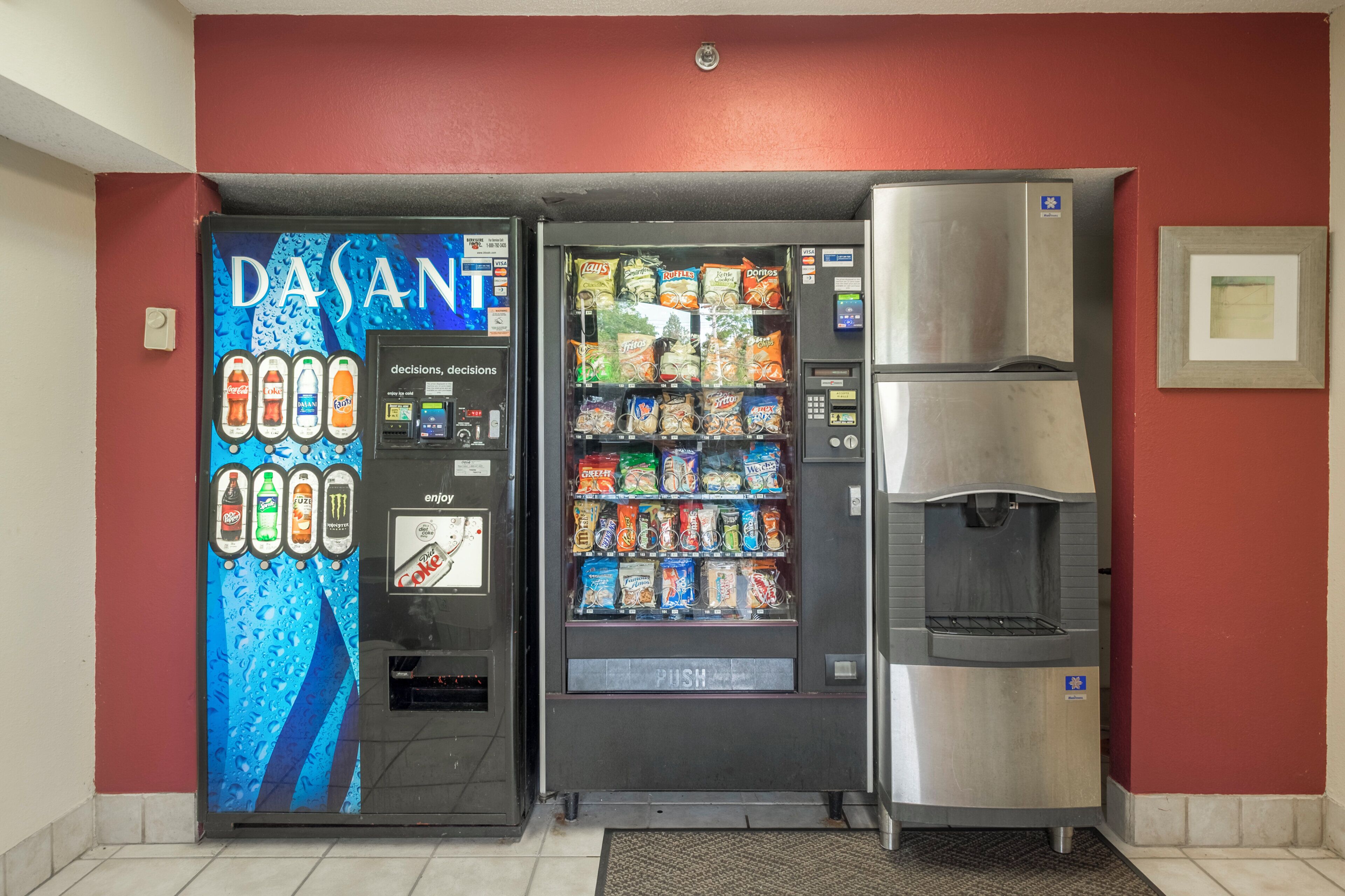 A vending machine with a variety of snacks and beverages, a water dispenser, and a door with a blue and white design.