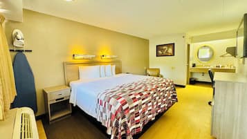 Una habitación de hotel con cama, una silla, un escritorio y baño.