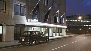 A building with a sign reading "thistle" and a black car parked in front. - Thistle Euston (London)
