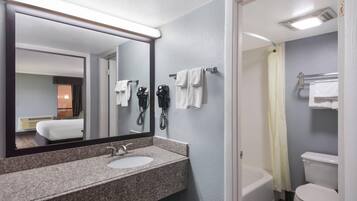 Une salle de bain avec un lavabo en granit, un miroir, des toilettes et un rideau de douche.