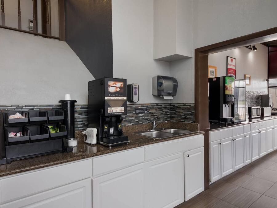 A modern kitchen with a coffee station, a sink, and a refrigerator.