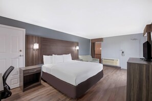 A hotel room with a large bed, bedside tables, a desk, and a chair. - Econo Lodge Austin North near The Domain (Austin)