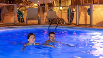 Una piscina al aire libre de temporada, sombrillas