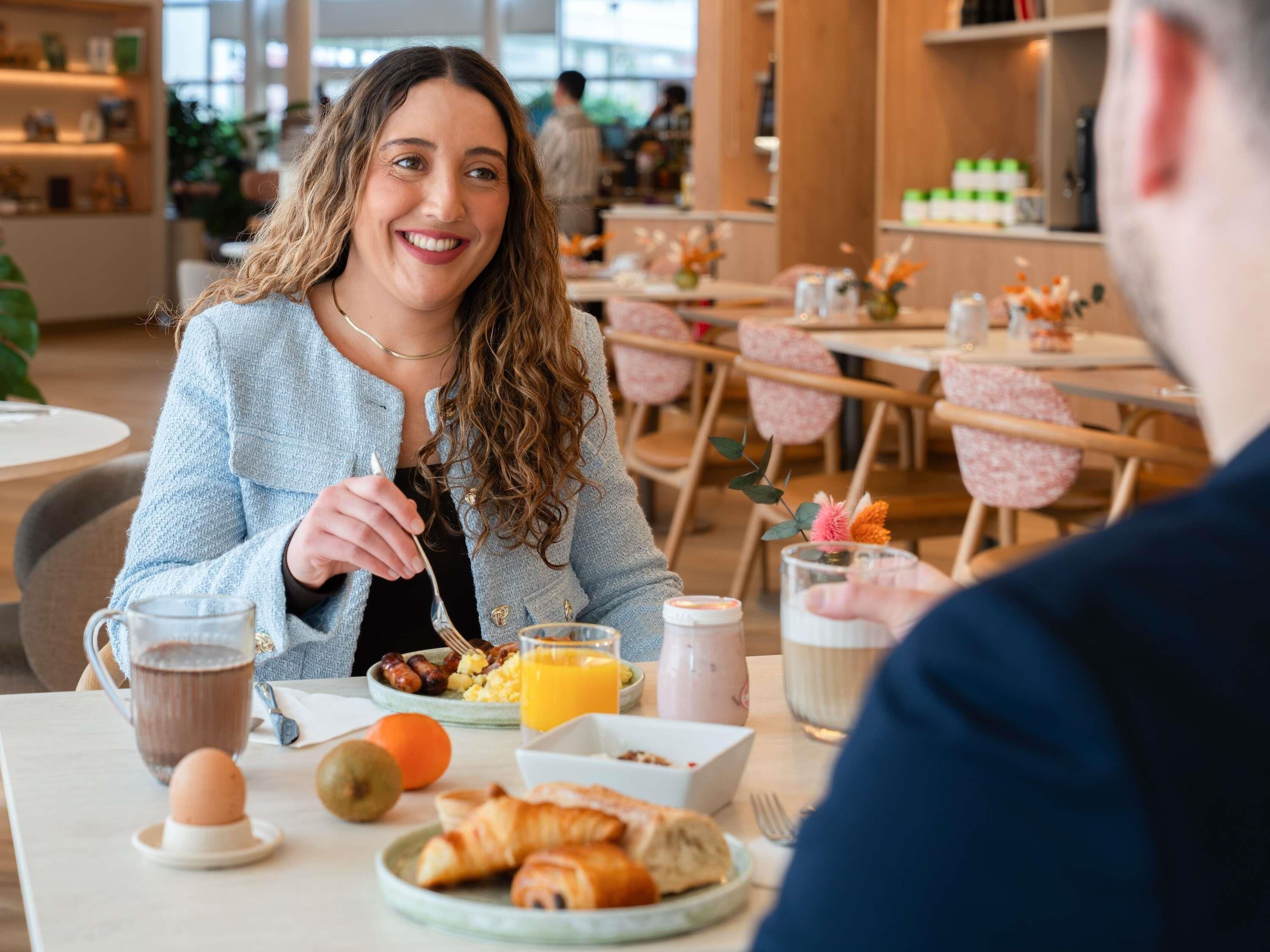 Una escena de desayuno con una mesa, platos de comida y una taza de café.
