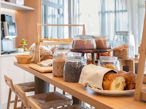 A bakery display with various breads and jars of ingredients.