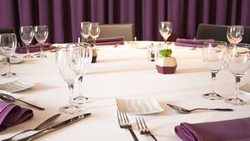 A table set for dining with wine glasses, cutlery, and a small decorative centerpiece.