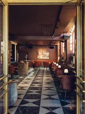A bar area with a checkered floor, bar stools, and a bar counter. - Radisson Collection, Strand Hotel, Stockholm (Stockholm)