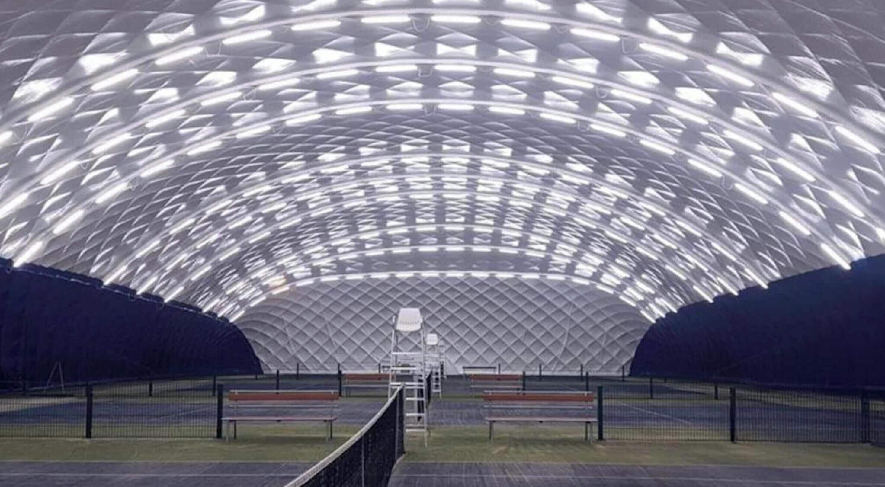 Una arena deportiva interior con una amplia estructura de techo curva y zonas de asientos.