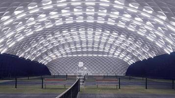 Una arena deportiva interior con una amplia estructura de techo curva y zonas de asientos.