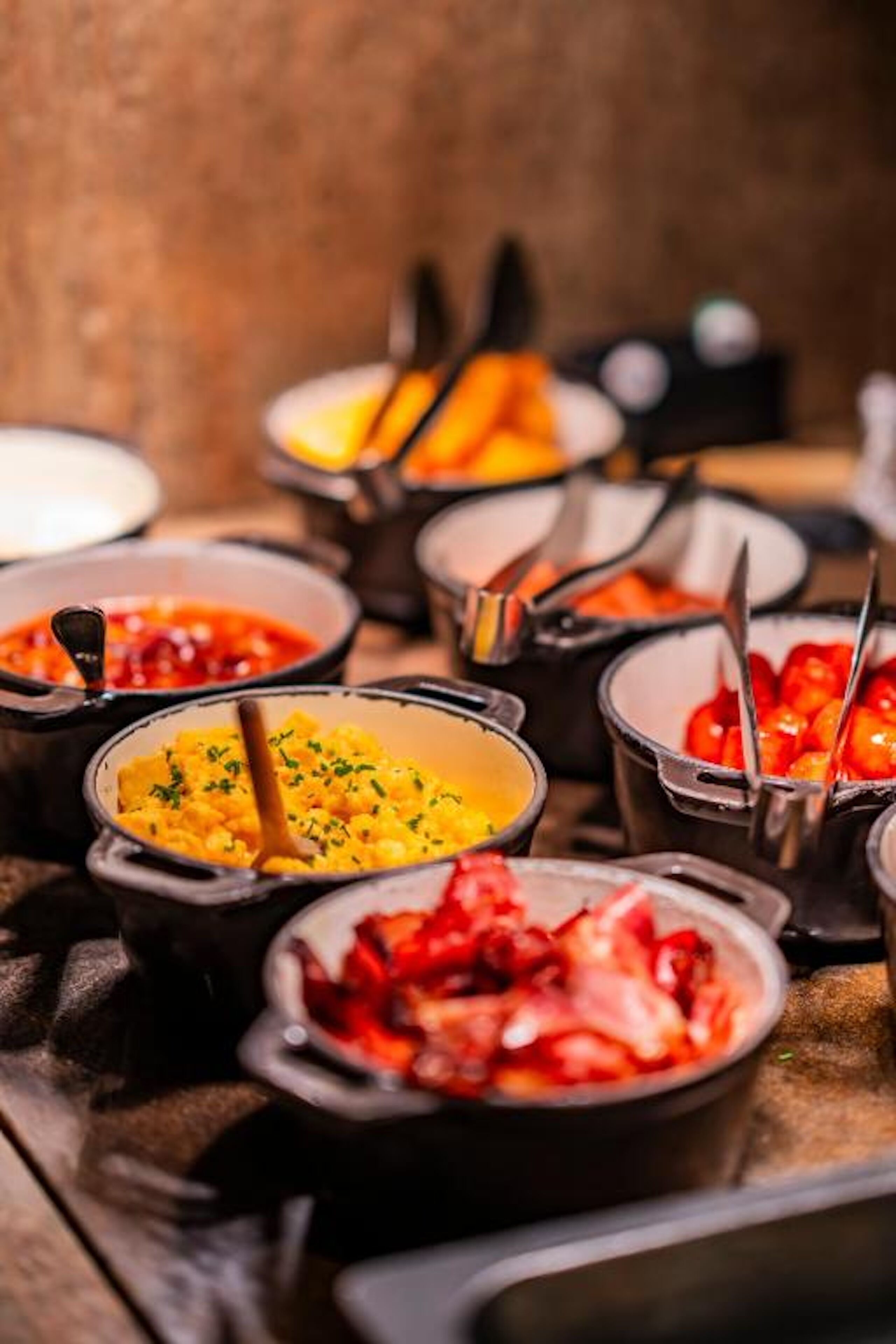 A buffet with various dishes in small bowls, arranged on a table.