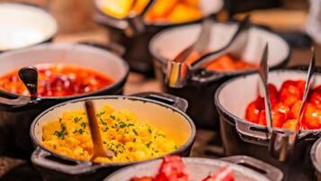 A buffet with various dishes in small bowls, arranged on a table.