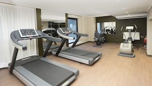 Un gimnasio moderno con cintas de correr, una bicicleta estática y una máquina de remo.