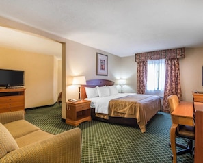 A hotel room with a bed, two bedside tables, a TV, a desk, and a chair.