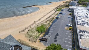 Ein Parkplatz am Strand mit Autos und Sand.