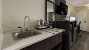 Una cocina moderna con un lavamanos doble, electrodomésticos de acero inoxidable y un armario de madera oscura.