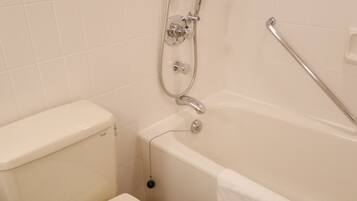 A bathroom with a white toilet, a bathtub, and a shower with a handheld showerhead.