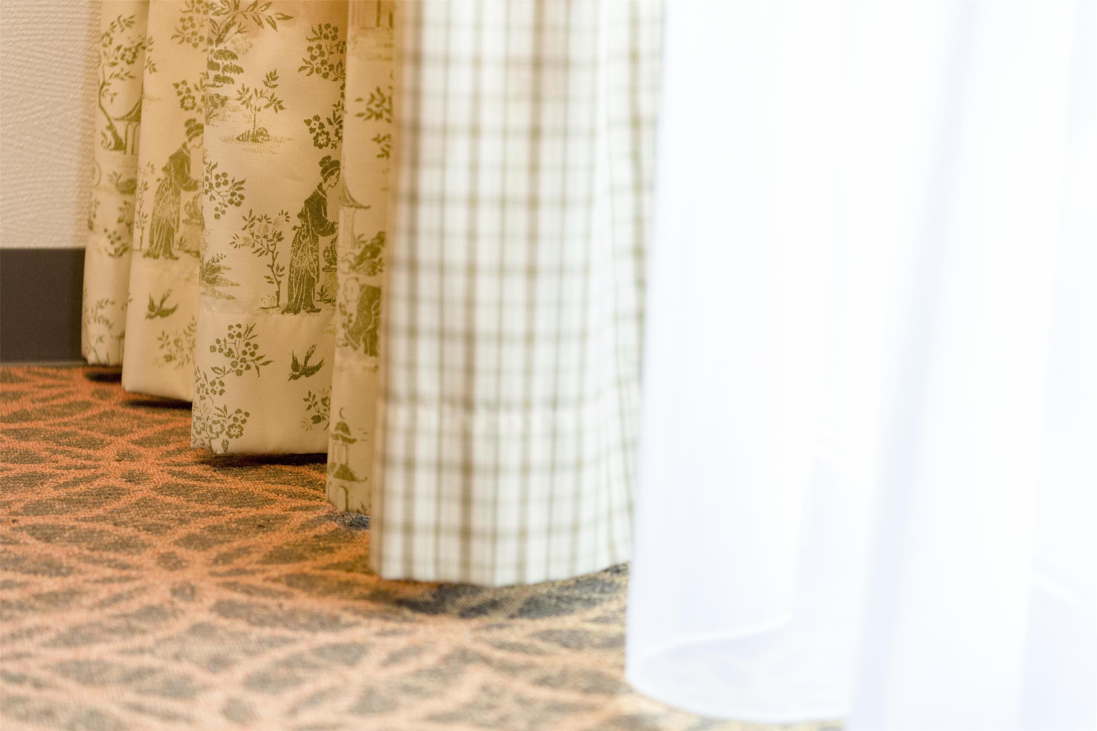 A patterned carpet and curtains with floral designs.