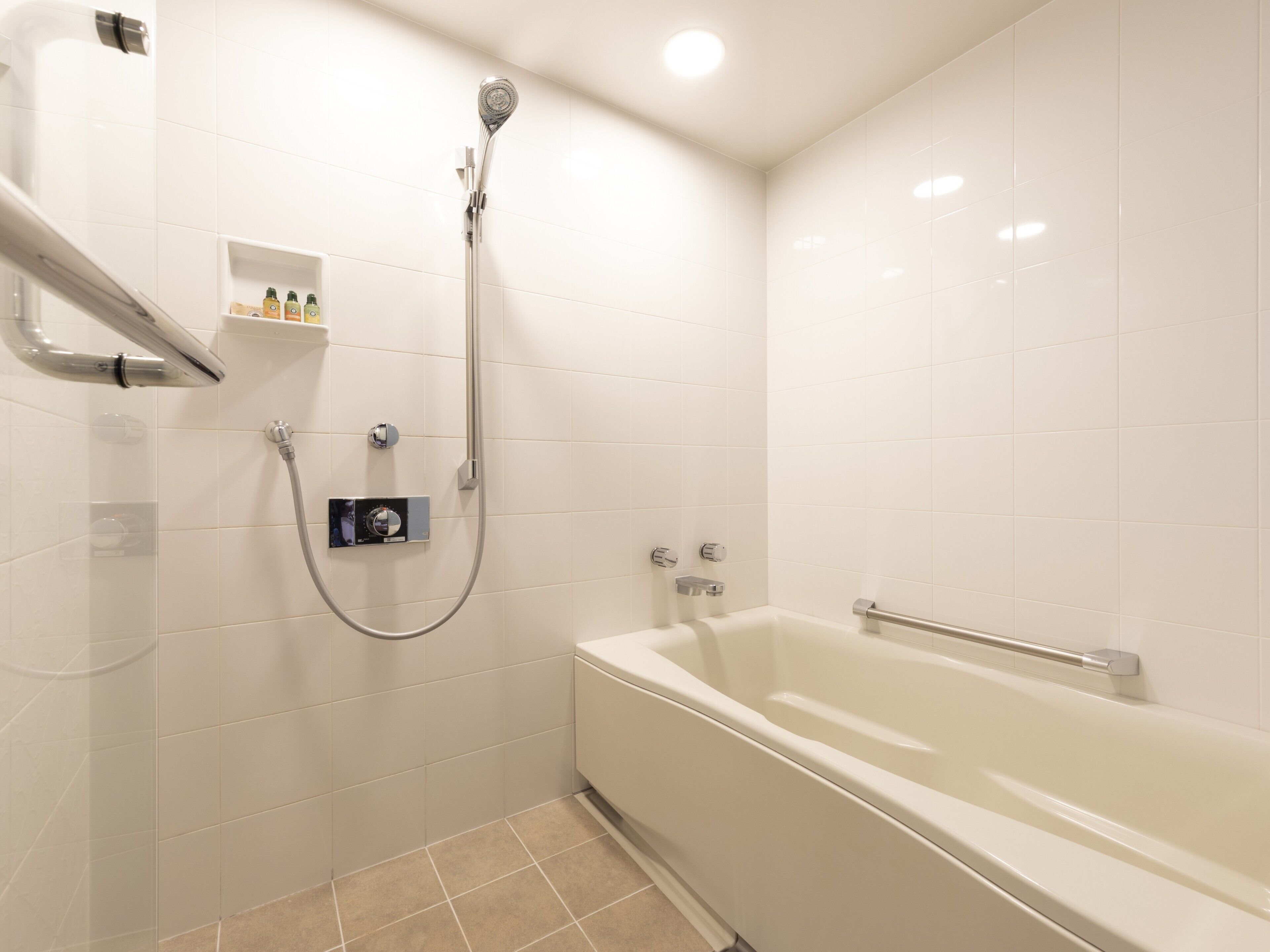 Un baño moderno con bañera, ducha y un panel de control.