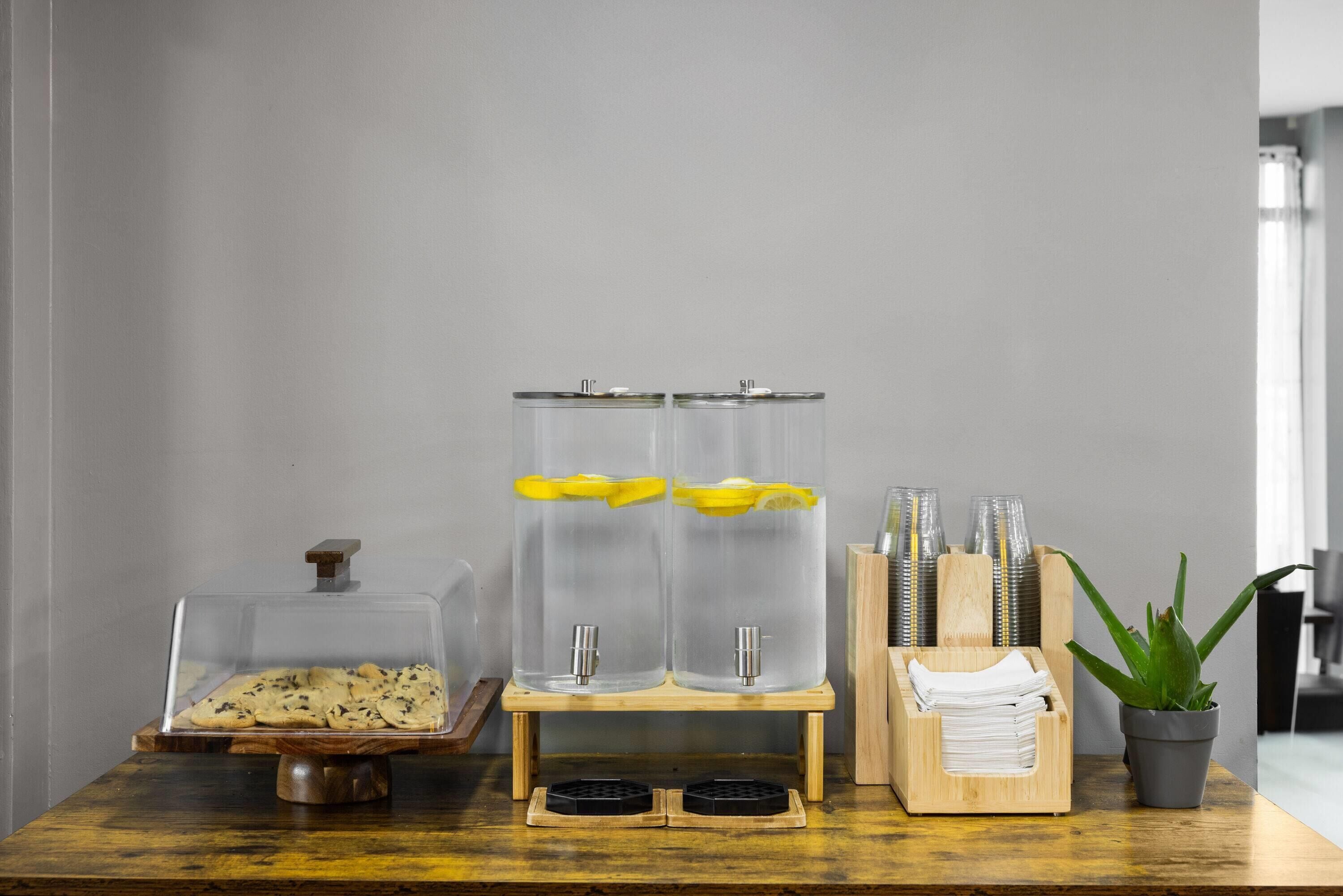 Una encimera de cocina con un tarro de galletas, un dispensador de agua y una planta.