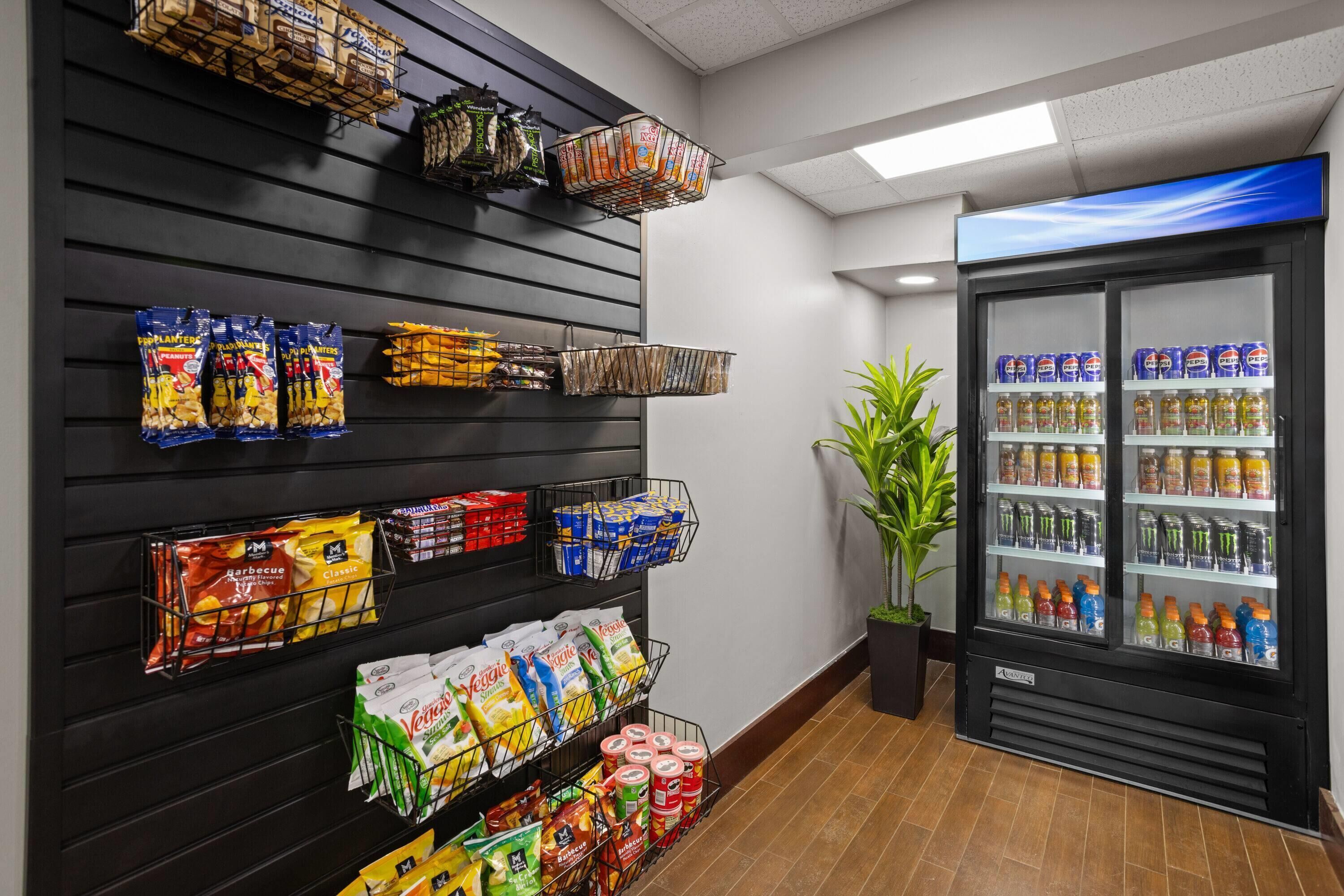 A snack display with various packaged foods and a refrigerated beverage cooler with multiple drinks.