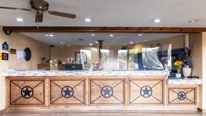 A kitchen with a wooden island featuring star designs, a ceiling fan, and a tiled backsplash. - Boerne Inn and Suites (Boerne)