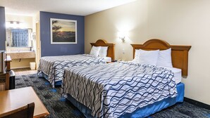 A hotel room with two beds, a bathroom, and a desk. - Boerne Inn and Suites (Boerne)