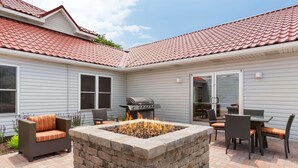 A patio with a fire pit, outdoor furniture, and a grill area. - Country Inn & Suites by Radisson, Holland, MI (Holland)