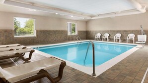 An indoor swimming pool with tiled flooring, lounge chairs, and a tiled wall. - Country Inn & Suites by Radisson, Holland, MI (Holland)