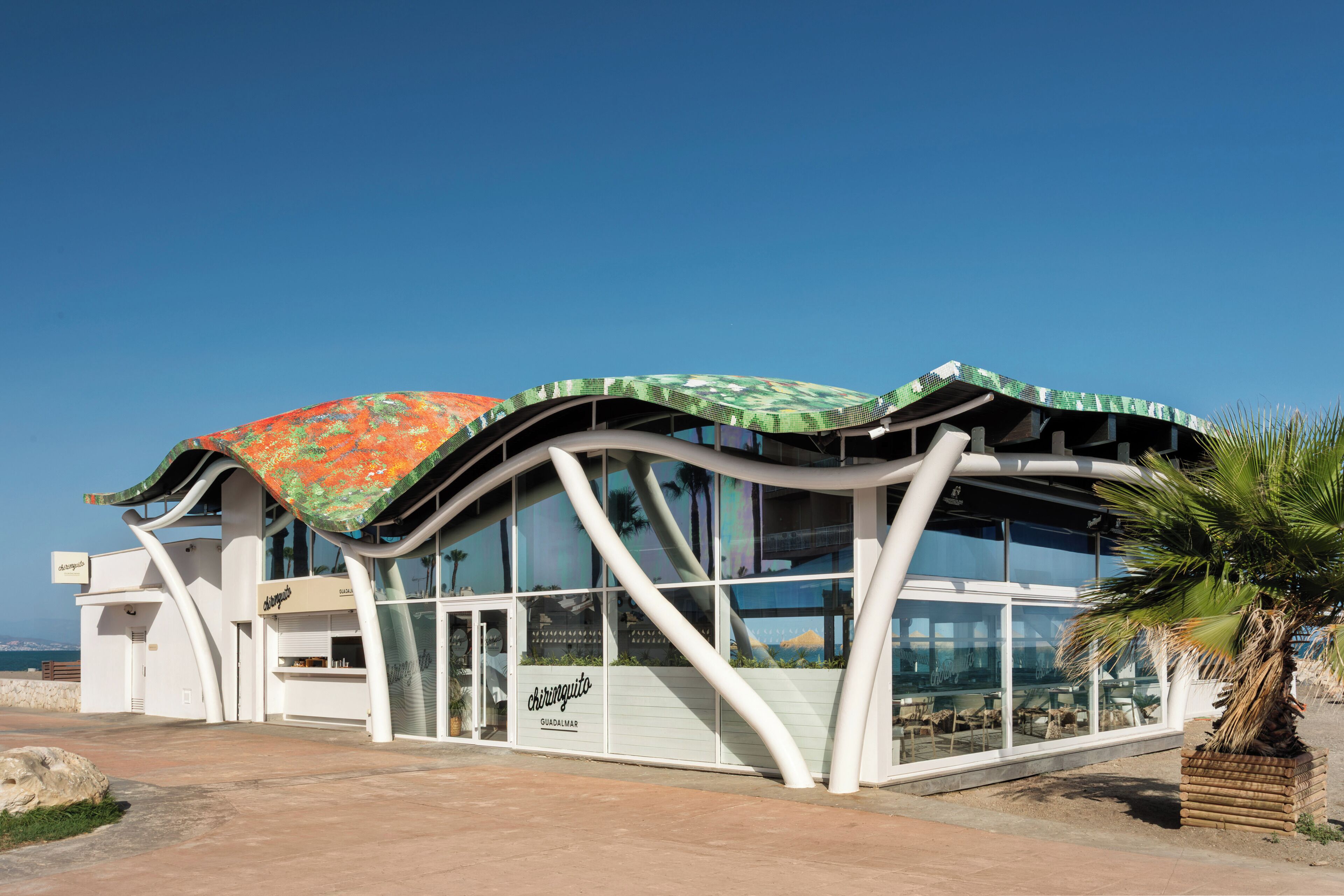 Un bâtiment moderne doté d’un toit incurvé et de grandes fenêtres.