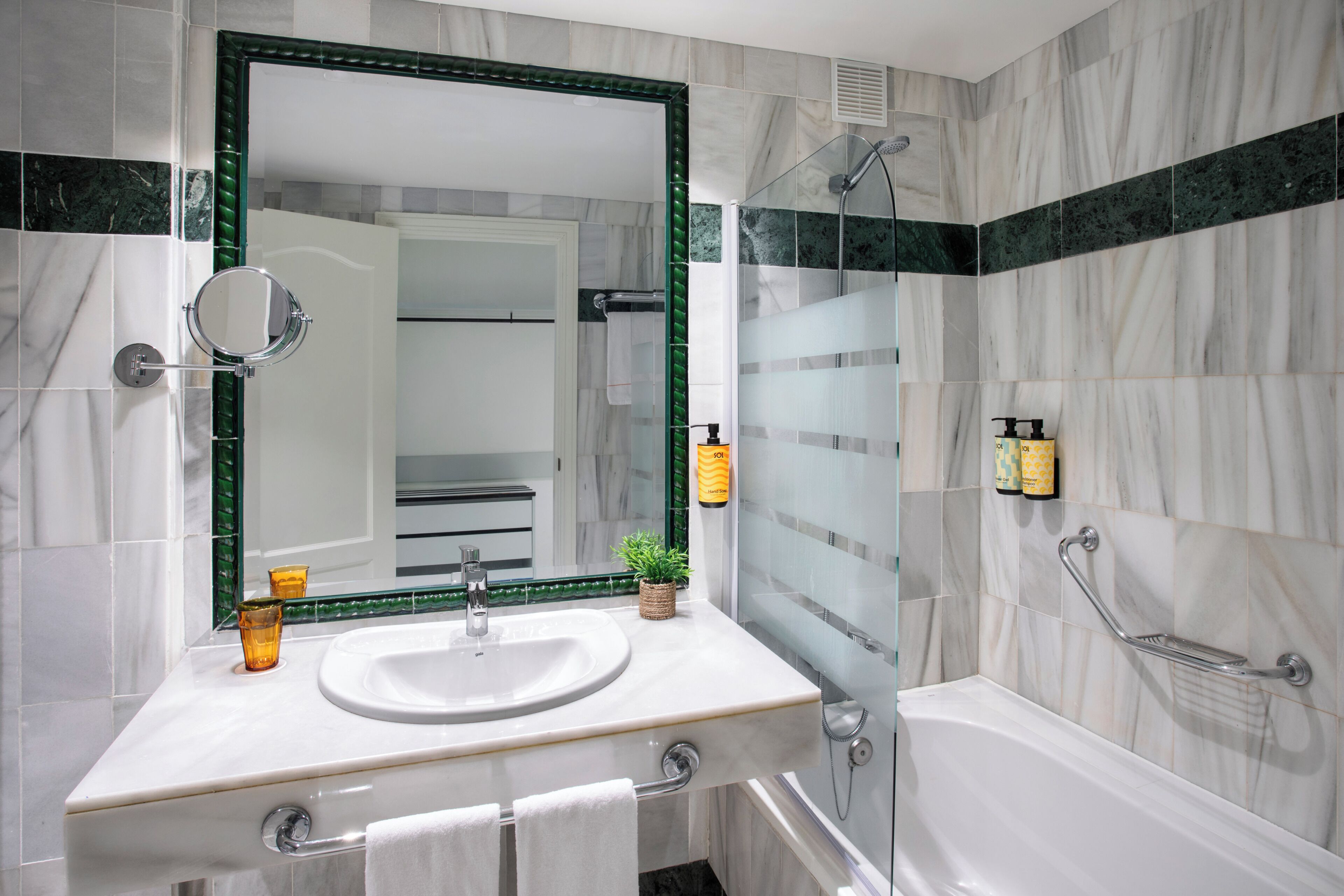 A modern bathroom with a large mirror, a sink, a shower, and a bathtub.
