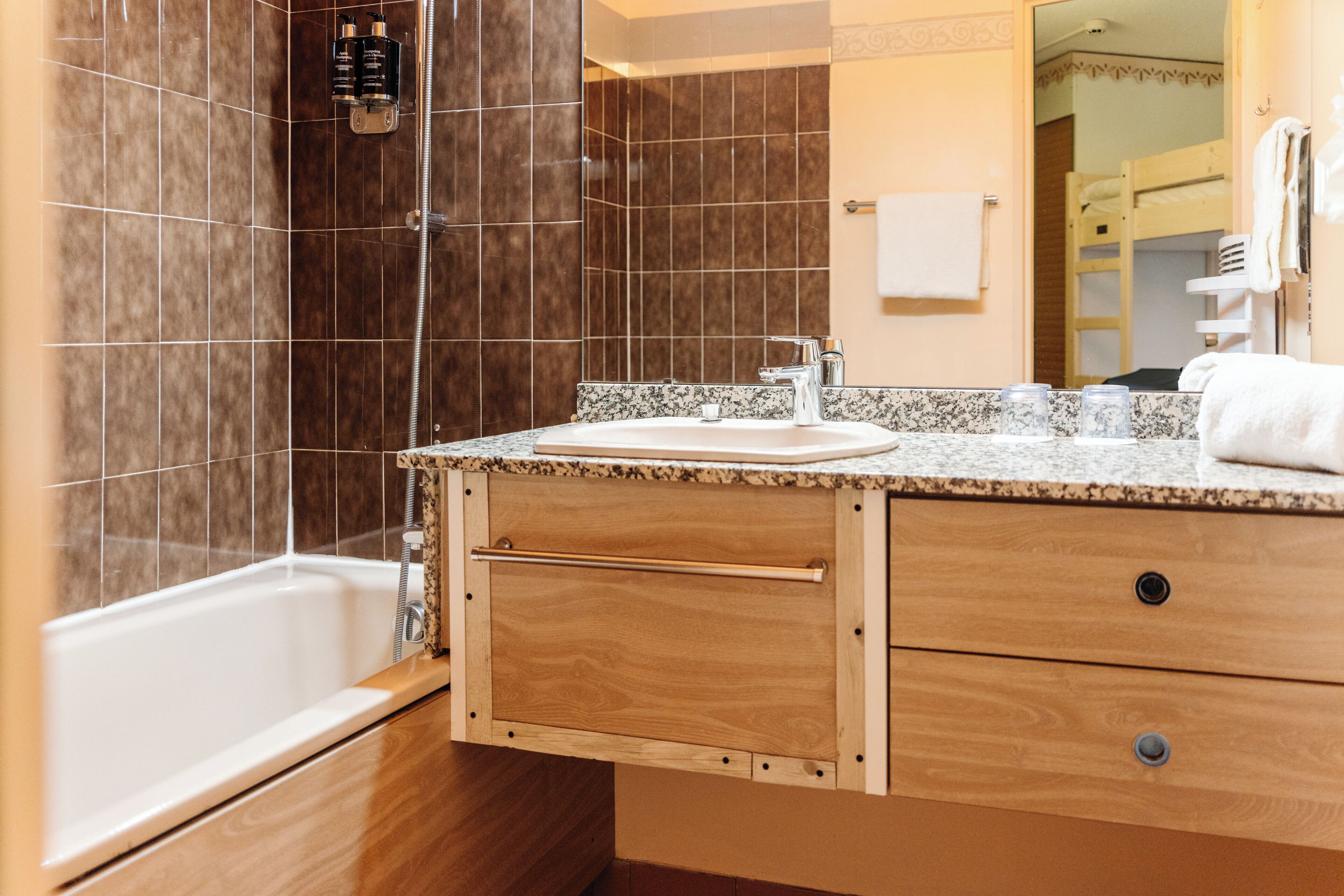 Ein Badezimmer mit Badewanne, einem hölzernen Waschtisch mit Waschbecken und einer Duschkabine.