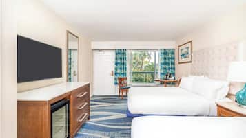 A hotel room with two beds, a TV, a desk, and a window with curtains.
