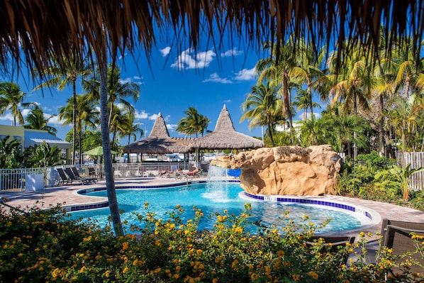 Alberca al aire libre, sombrillas en la alberca y camastros 