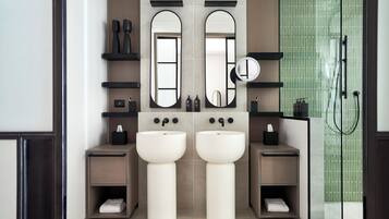 Une salle de bain moderne avec deux lavabos, des miroirs et un espace douche.