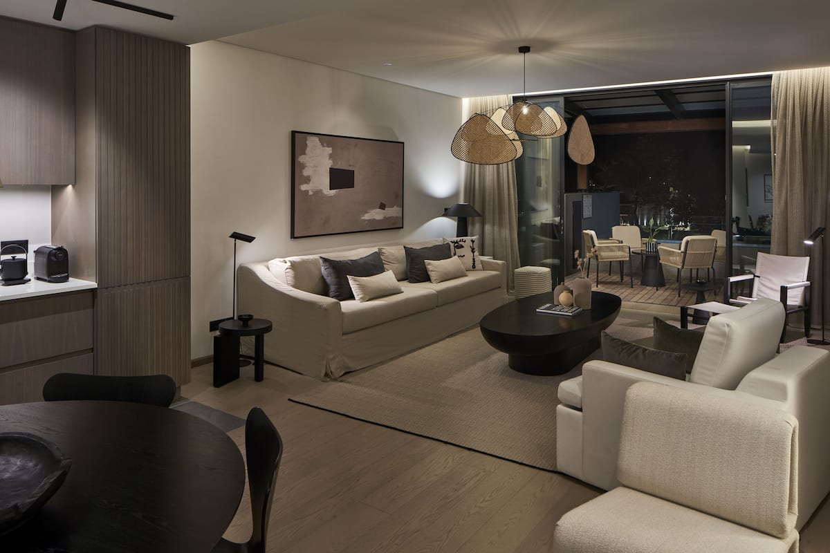 Een moderne woonkamer met een bank, salontafel en een eethoek.