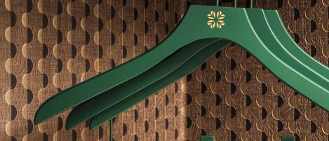 A green hanger with a decorative emblem on a textured wall.