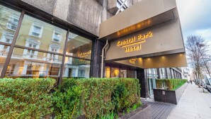 The exterior of the Central Park Hotel with a modern facade, large windows, and a well-maintained hedge in front. - Central Park Hotel (London)