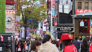 A busy urban street with various shops and advertisements.