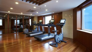 A gym with treadmills, elliptical machines, and a mirrored wall. - Sejong Hotel (Seoul)