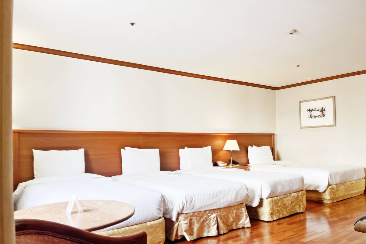 Habitació d'hotel amb dos llits, una taula petita i una cadira.