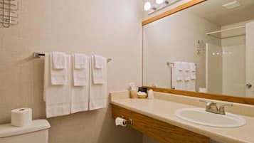 A bathroom with a sink, mirror, and towels.