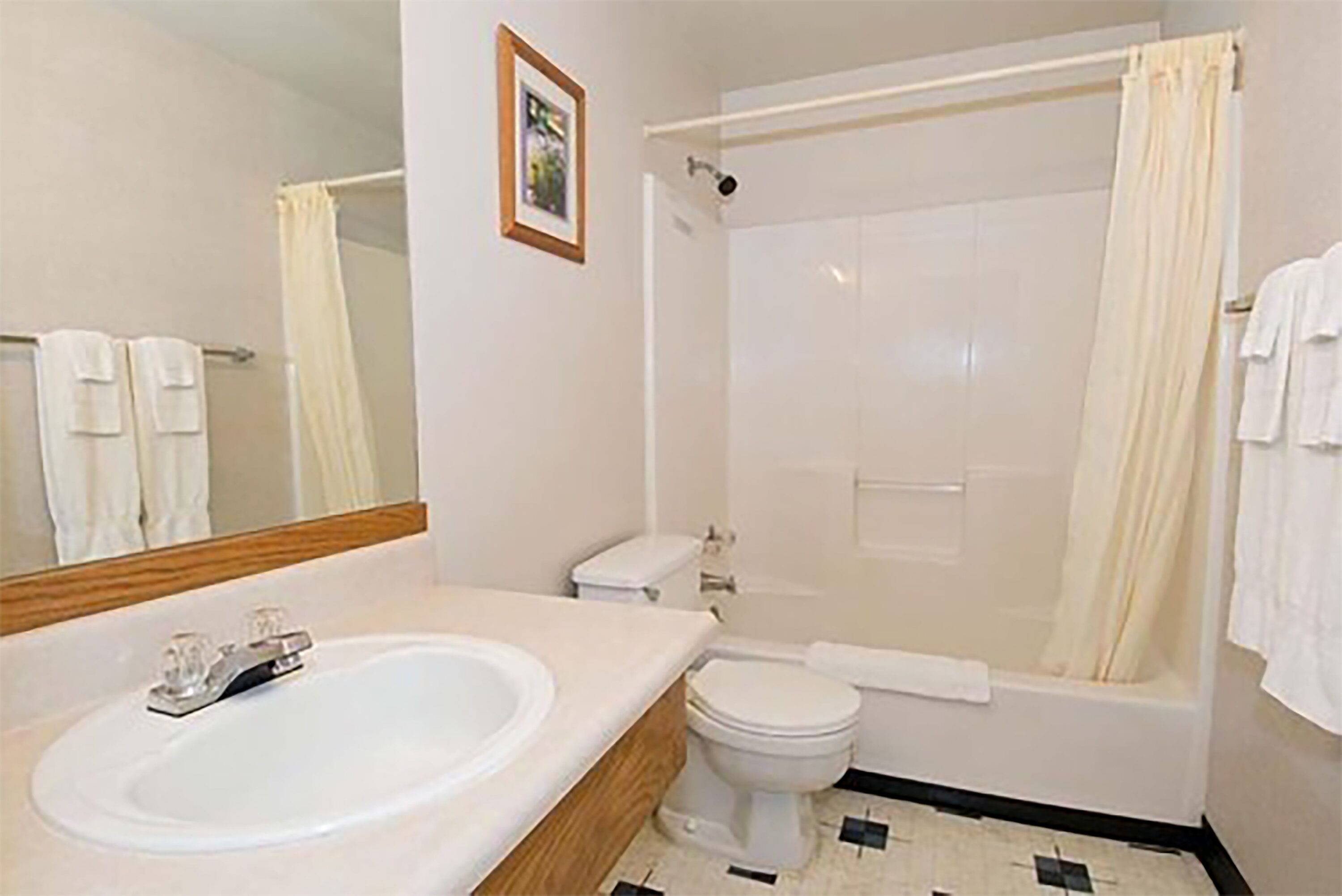 A bathroom with a sink, toilet, and shower.