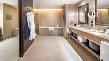 Un baño moderno con un espejo grande, una bañera, una ducha y un lavamanos con un lavabo.