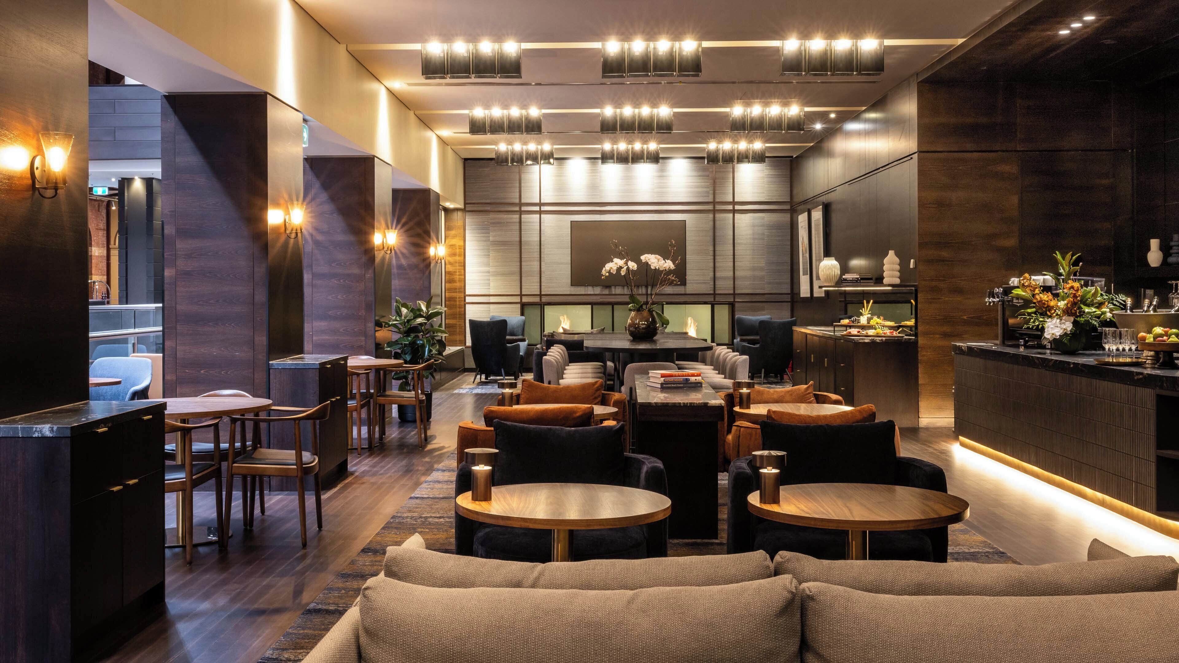 Un interior moderno con una zona de bar, asientos y una chimenea.