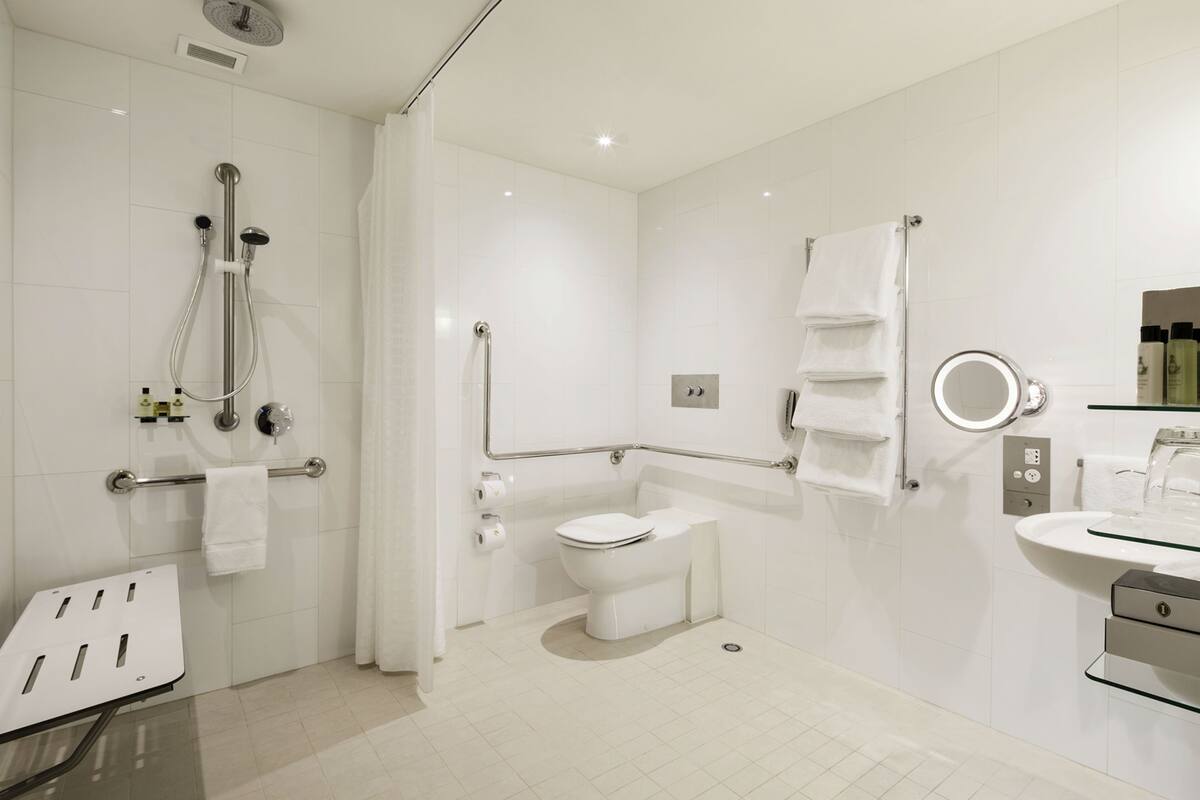 A modern bathroom with a shower, toilet, and sink.