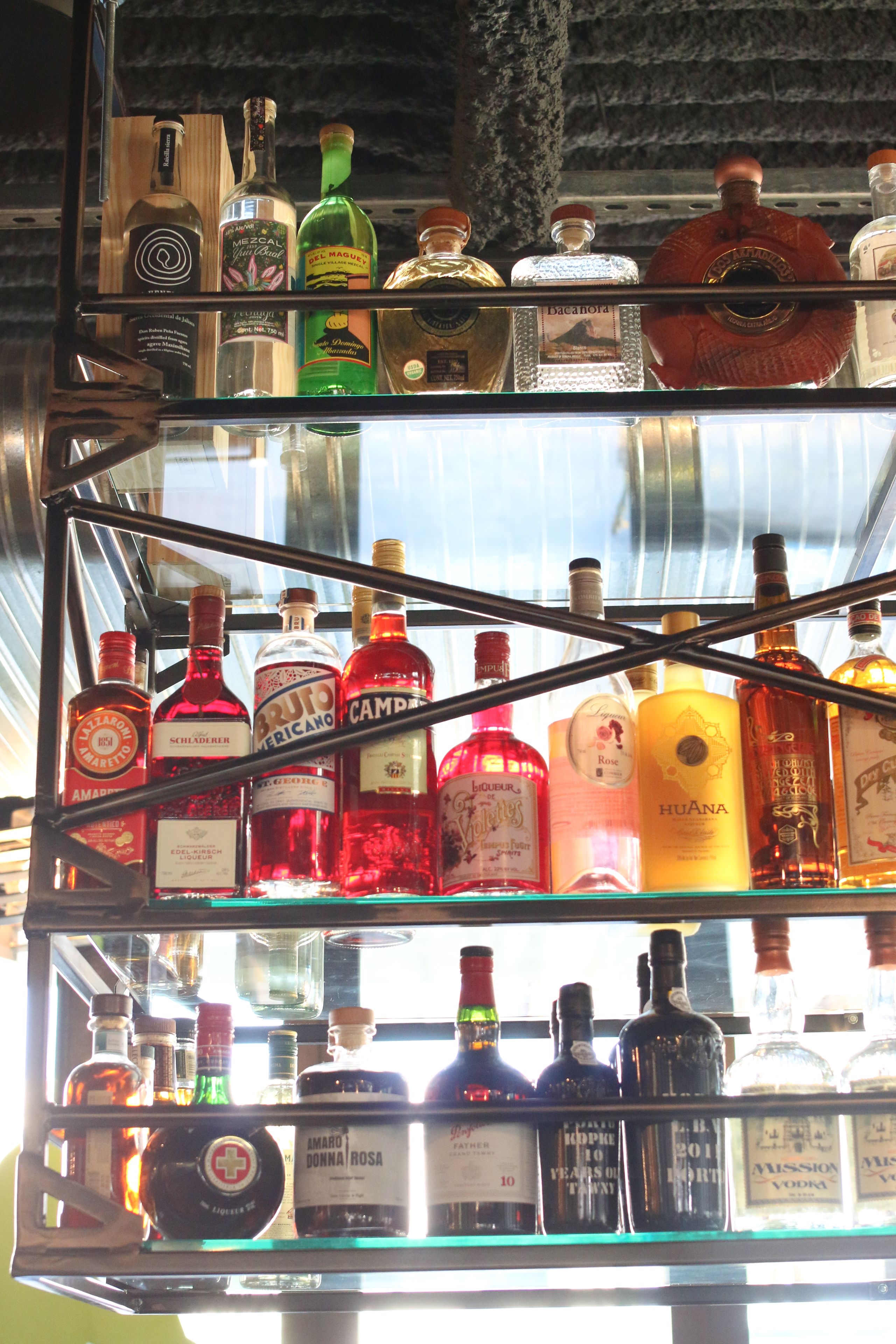 Una licorería con múltiples estantes llenos de diversas botellas de licor.